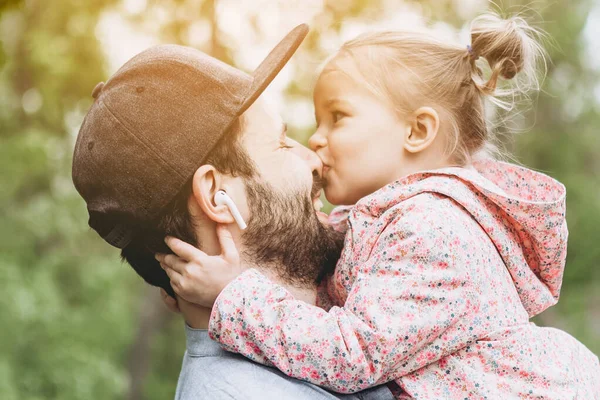 Baba ve kızı ormanda birlikte yürüyorlar. Ebeveynlerinin birlikte çok zaman geçirdiği çocuklar için mutlu çocukluk kavramı.