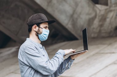 Coronavirus salgını ve serbest çalışma evde çalışmaktan ve dışarı çıkmaktan bıkmış koruyucu bir maske takıyor.