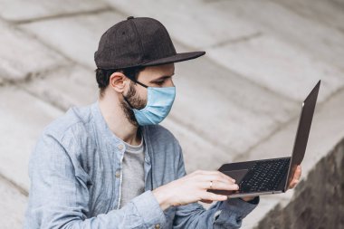 Coronavirus salgını ve serbest çalışma evde çalışmaktan ve dışarı çıkmaktan bıkmış koruyucu bir maske takıyor.
