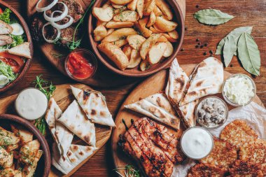 Büyük ve cömertçe nefis yemek masalarıyla kaplı ve üzerinde Ukrayna mutfağının çeşitli yemekleri var: barbekü, kızarmış patates, salata, sos, peynirli pita ekmeği.