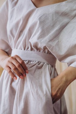 Çekici sarışın bir kadının portresi açık beyaz elbise giymiş bir kadın giyim mağazasının reklamı için poz veriyor.