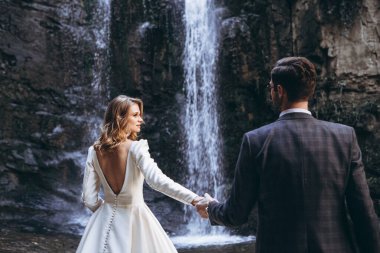 Gürcü kükürt banyosunun çatısında eski şehir arka planında fotoğraf çektirmek için zarif bir gelinlik giymiş güzel genç kız.