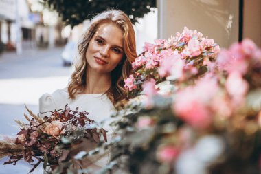 Gürcü kükürt banyosunun çatısında eski şehir arka planında fotoğraf çektirmek için zarif bir gelinlik giymiş güzel genç kız.