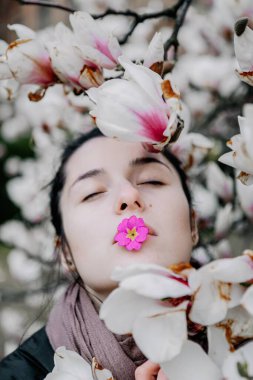 Genç kız Ukrayna 'daki Chernivtsi Üniversitesi' nde beyaz ve pembe manolya çiçeklerinin çiçeklenmesinin tadını çıkarıyor.