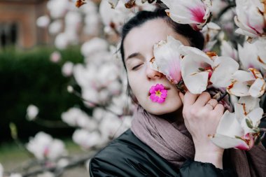 Genç kız Ukrayna 'daki Chernivtsi Üniversitesi' nde beyaz ve pembe manolya çiçeklerinin çiçeklenmesinin tadını çıkarıyor.