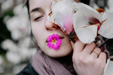 Genç kız Ukrayna 'daki Chernivtsi Üniversitesi' nde beyaz ve pembe manolya çiçeklerinin çiçeklenmesinin tadını çıkarıyor.