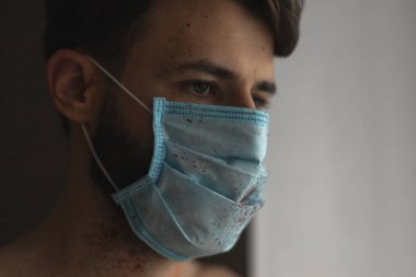 Maskeli genç adam evde karantinaya alınır ve hastalığını başkalarından gizler.