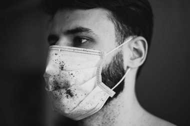 Koruyucu tıbbi maske takan genç adam virüs hastalığıyla karantinada.