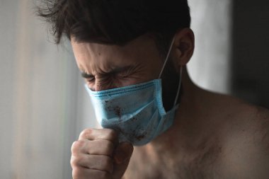 Maskeli genç adam evde karantinaya alınır ve hastalığını başkalarından gizler.