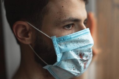Maskeli genç adam evde karantinaya alınır ve hastalığını başkalarından gizler.