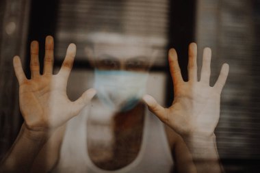 Maskeli genç adam evde karantinaya alınır ve hastalığını başkalarından gizler.