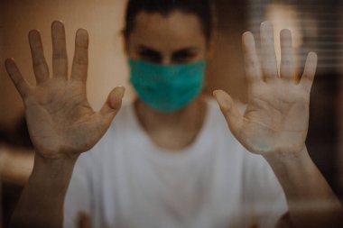 seçici odak, gürültü etkisi: viral hastalıklar salgını sırasında tıbbi maske takan kadın evde karantinaya alındı