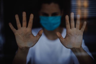 seçici odak, gürültü etkisi: viral hastalıklar salgını sırasında tıbbi maske takan kadın evde karantinaya alındı