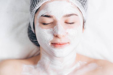 Spa 'daki müşterinin portresi. Gerçek doğal güzelliğe sahip bir kadın, doktoruyla düzenli estetik ameliyatta olan genç bir esmer.