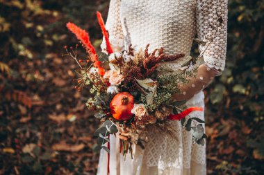 Gelinlik giymiş bir kızın ellerinde güzel bir buket.