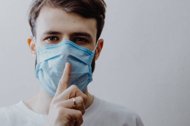 Virüs hastalığının yayılma konsepti: tıbbi maske takan genç bir adam, ama hasta hastalığını başkalarından saklıyor ve onları riske atıyor.