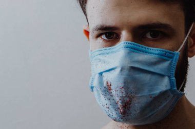 Coronavirüs salgını sırasında maskeli bir adamın portresi. Tehlikeli bir viral hastalığın belirtileri: Boğaz ağrısı, öksürük, ateş.
