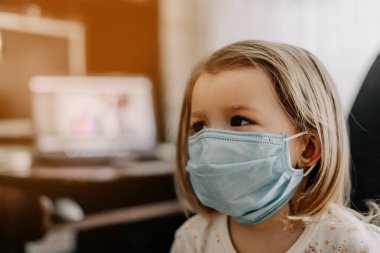 Coronavirus Covid-19 ve Hava kirliliği konsepti. Evdeki PM2.5 'u korumak için maske takan beyaz bir kız. Covid-19 koronavirüs ve salgın virüs belirtileri..