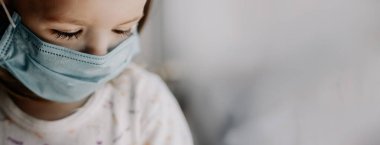 Coronavirus Covid-19 ve Hava kirliliği konsepti fotokopi uzayı. Evdeki PM2.5 'u korumak için maske takan beyaz bir kız. Salgın virüs belirtileri.