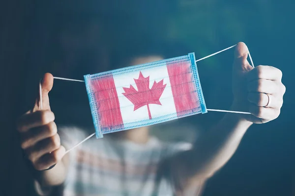 Maschera Medica Nelle Mani Dell Uomo Con Bandiera Del Canada — Foto Stock