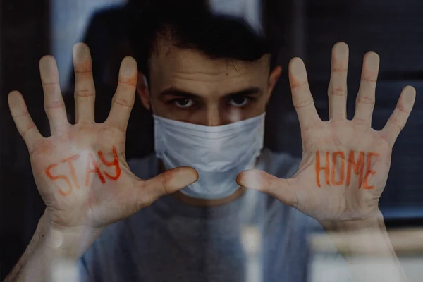 Ung Man Tittar Genom Fönstret Med Inskriptionen Stay Home Handflatan — Stockfoto
