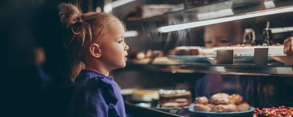 Mooi Meisje Bewonderenswaardig Onderzoekt Een Verlichte Vitrine Met Verschillende Heerlijke — Stockfoto