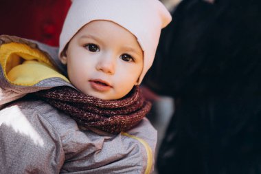 Anne ve bebeğin çocuk parkında sonbahar yürüyüşü. Tatlı bir çocuk salıncakta sallanıyor, lunapark treninden iniyor, gülüyor ve seviniyor..