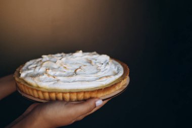 Lezzetli limonlu pasta. Geleneksel Fransız tatlı turtası. Lezzetli, iştah açıcı, ev yapımı limon kremalı tatlı. Uzayı kadın ellerine kopyala