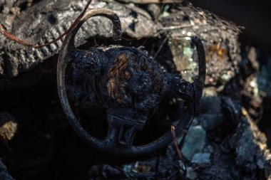 Yangından sonra araba. Kaputu açık yanmış bir araba. Kundaklama, yanmış araba. Yanmış iç süsleme, direksiyon, gösterge paneli,