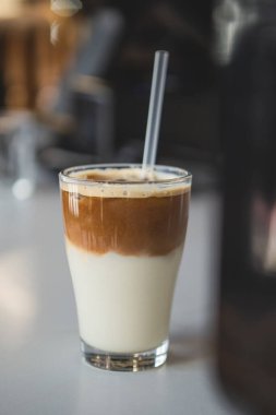 Bardakta buzlu kahve, dikey çekim, koyu arkaplan.