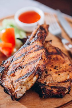 İki iştah açıcı pirzola. Tahtada sebzeli ve ızgara sebzeli.