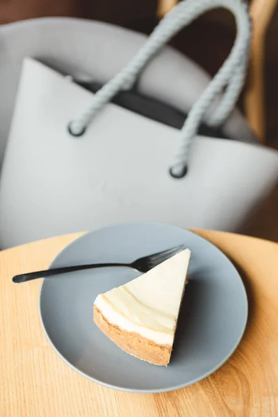 a slice of cheesecake prepared according to the classic recipe: made of shortbread cookies, butter, cream and cottage cheese. Cheesecake on a plate in a harmonious color combination with other details of a photo
