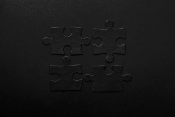 Cztery Czarne Puzzle Ciemnym Tle — Zdjęcie stockowe