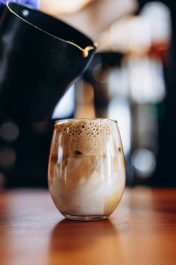 Süt ve buzlu köpüklü şeffaf bardak. Bar masasındaki Dalgano kahvesinin yaz versiyonu.