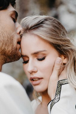 Ses efekti, seçici odak: dağlarda fotoğraf çekerken damadına sarılıp öpen çekici gelinin portresi