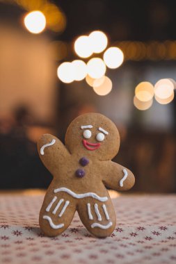 Mutlu Noeller ve mutlu yıllar: Kafe ya da fırın kavramı, Noel ağacı ve çelenklerin önünde duran havalı zencefilli kurabiye resmi