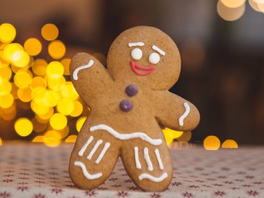 Mutlu Noeller ve mutlu yıllar: Kafe ya da fırın kavramı, Noel ağacı ve çelenklerin önünde duran havalı zencefilli kurabiye resmi