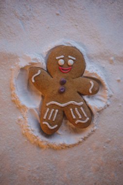 Mutlu yıllar: kızıl küçük adam yerde yatıyor ve elleri ve ayaklarının yardımıyla karda ayak izi bırakan bir meleğin şeklini alıyor.