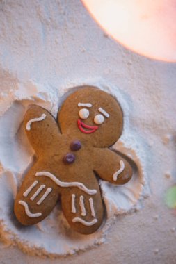 Mutlu yıllar: kızıl küçük adam yerde yatıyor ve elleri ve ayaklarının yardımıyla karda ayak izi bırakan bir meleğin şeklini alıyor.