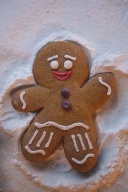 Mutlu yıllar: kızıl küçük adam yerde yatıyor ve elleri ve ayaklarının yardımıyla karda ayak izi bırakan bir meleğin şeklini alıyor.