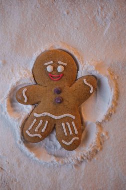 Mutlu yıllar: kızıl küçük adam yerde yatıyor ve elleri ve ayaklarının yardımıyla karda ayak izi bırakan bir meleğin şeklini alıyor.