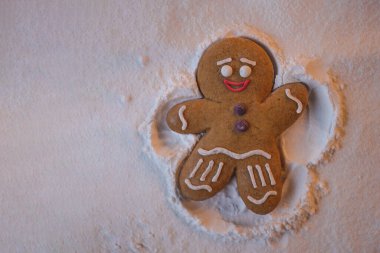 Mutlu yıllar: kızıl küçük adam yerde yatıyor ve elleri ve ayaklarının yardımıyla karda ayak izi bırakan bir meleğin şeklini alıyor.