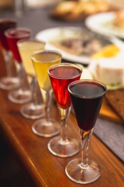 Meyve ve alkole dayalı farklı renkli tentürlere sahip bardaklar. Bayram yemeğinden önce nefis bir aperatif.