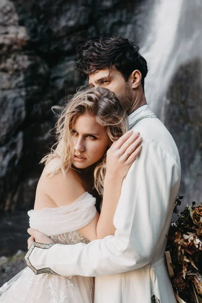 噪声效应 有选择的焦点 在山区拍照时迷人的新娘拥抱和亲吻新郎的肖像 — 图库照片