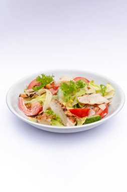 İzole edilmiş beyaz arka plana sosla karıştırılmış taze salata içerikli beyaz tabaklar. Menü, pankart veya reklam için bir yer