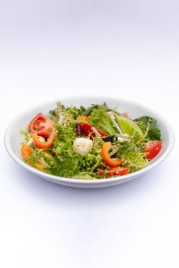 İzole edilmiş beyaz arka plana sosla karıştırılmış taze salata içerikli beyaz tabaklar. Menü, pankart veya reklam için bir yer