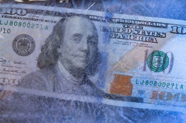 Buz tabakasının altında dondurulmuş Amerikan doları, küresel ekonomik kriz kavramı veya dünya piyasasında doların düşüşü