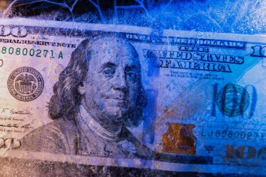 Yeni 100 dolarlık banknot buz tabakasının altında, küresel ekonomik kriz konsepti veya doların dünya piyasasına düşüşü