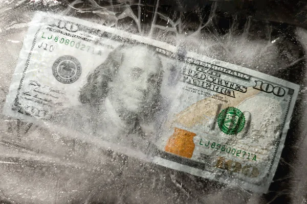 Yeni 100 dolarlık banknot buz tabakasının altında, küresel ekonomik kriz konsepti veya doların dünya piyasasına düşüşü