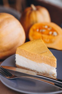 Bir parça balkabağı ev yapımı kek. Bayramlık tatlı konsepti. kabak turtası, rahat kafe arka planı, seçici odak, gürültü efekti